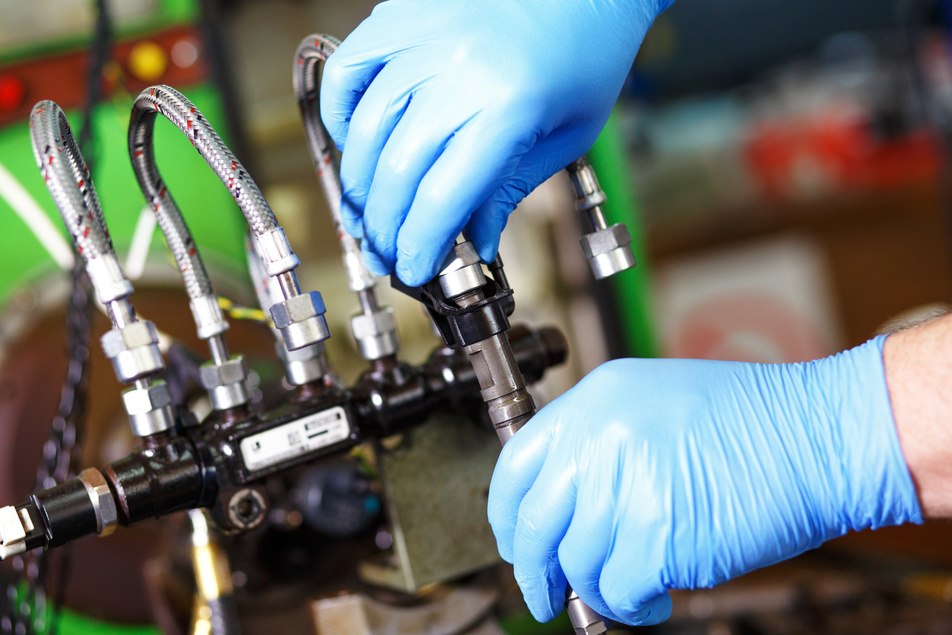 car mechanic performing a fuel injection service