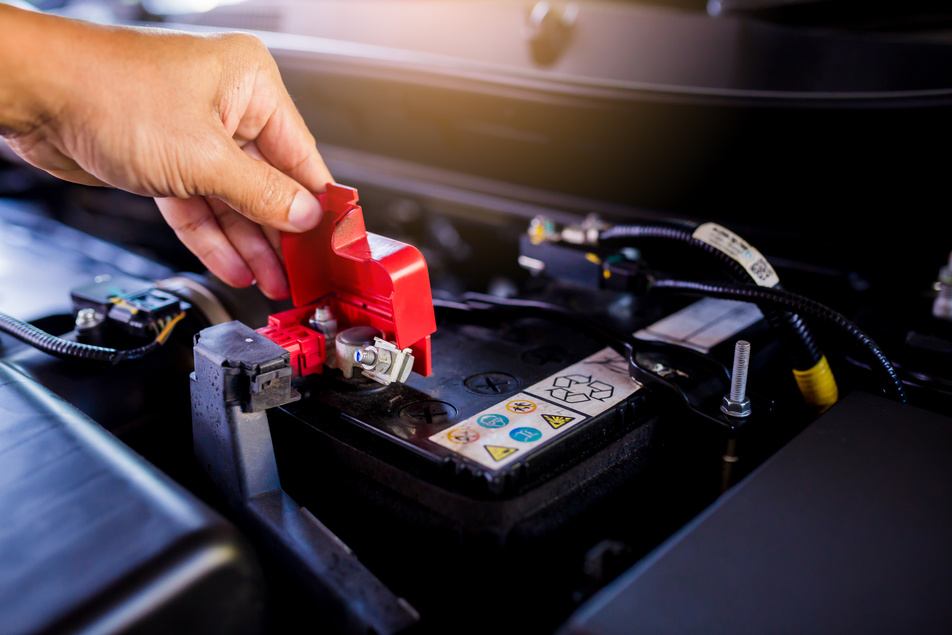 mechanic inspecting car battery during routine maintenance inspection