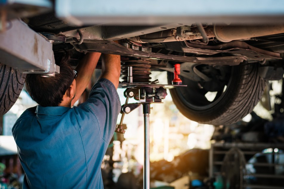 mechanic repairing vehicle's suspension system