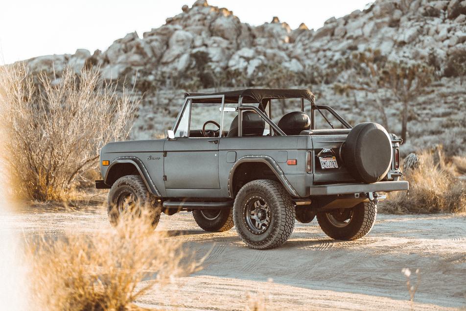 vehicle with lift kit installed driving through rough terrain