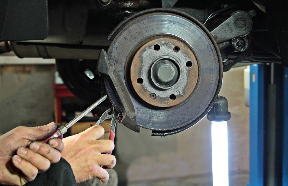 mechanic repairing worn brake pad