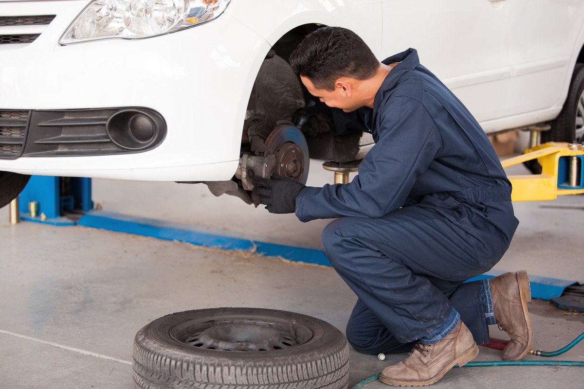 mechanic repairing vehicle brakes