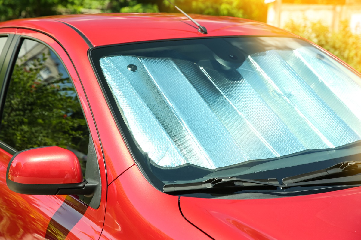 car owner using sun shades to keep car cool in summer