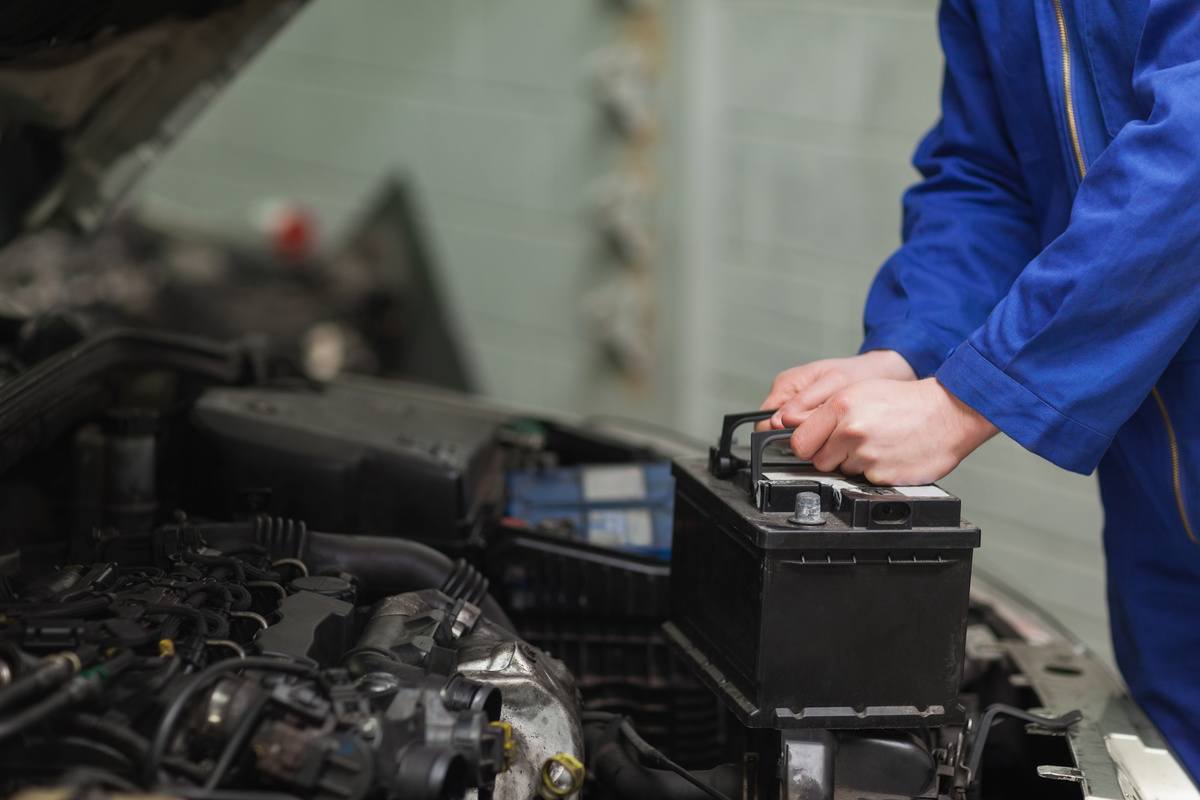car mechanic repairing car battery