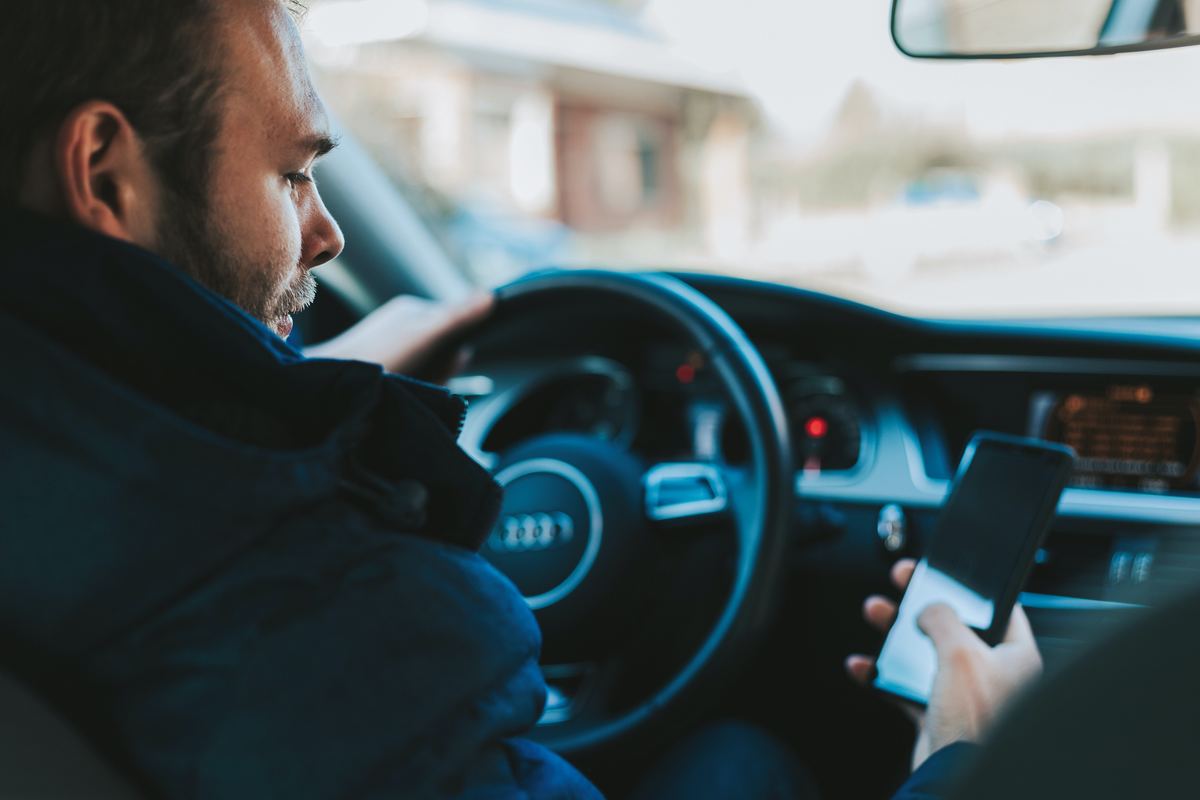 driver distracted by cellphone on road