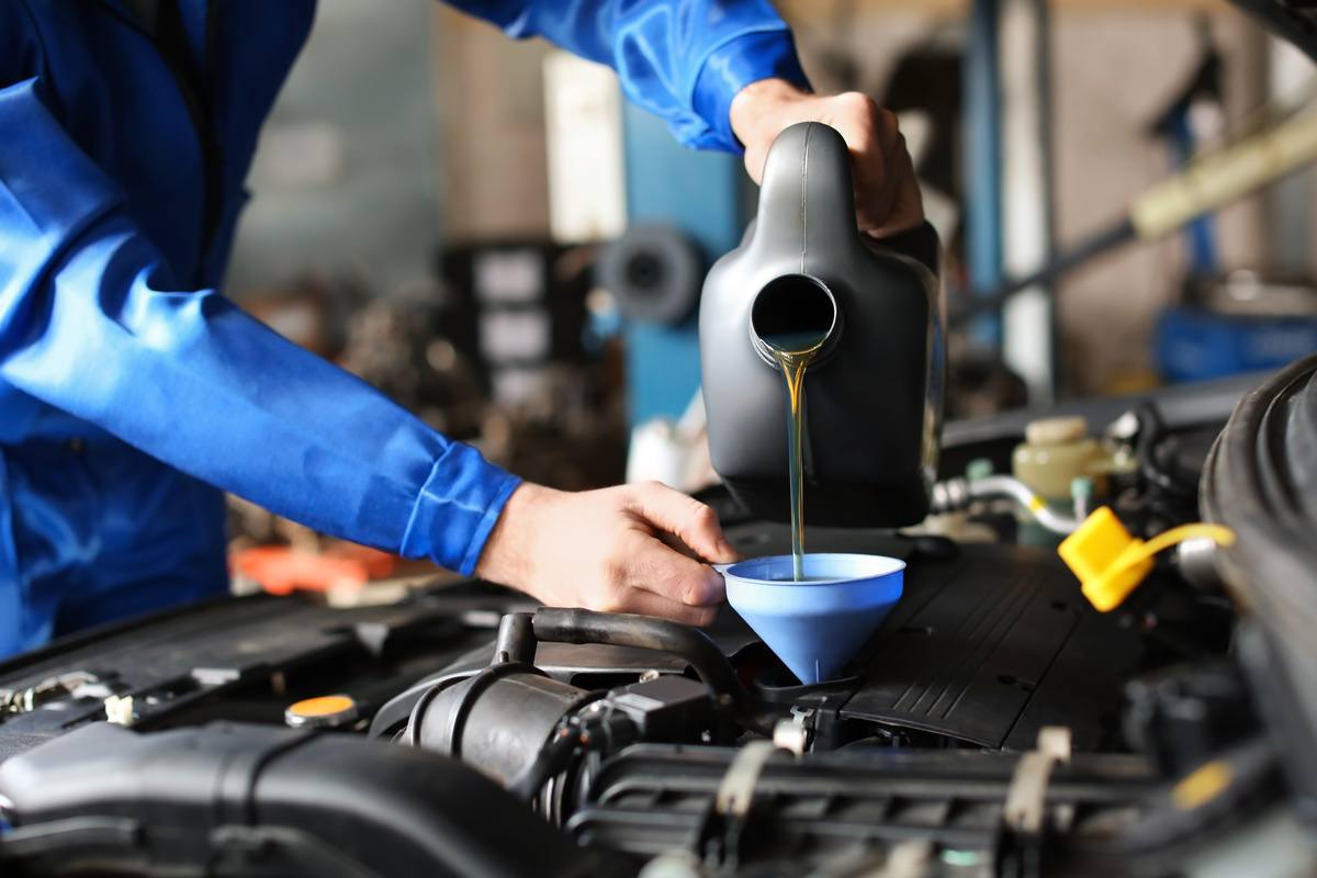 mechanic putting the right engine oil in car