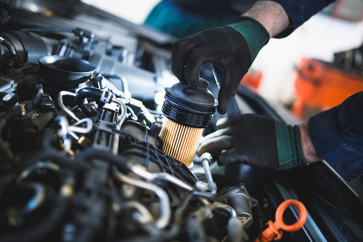 mechanic changing filter in car