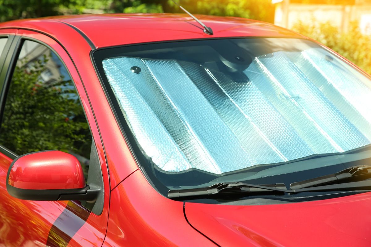 car owner using sun shades to keep car cool in summer