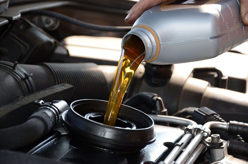 synthetic blend oil being poured into oil compartment in vehicle